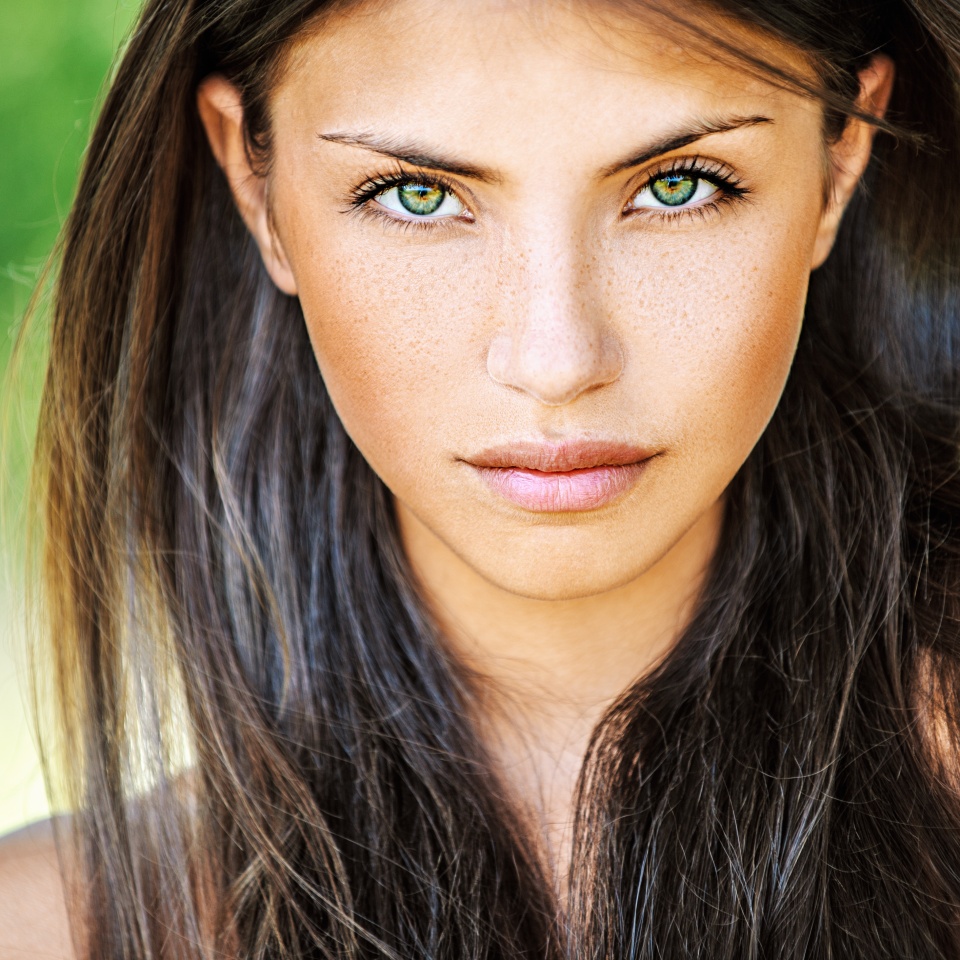 Portrait close up of young beautiful woman, on green background summer nature.
