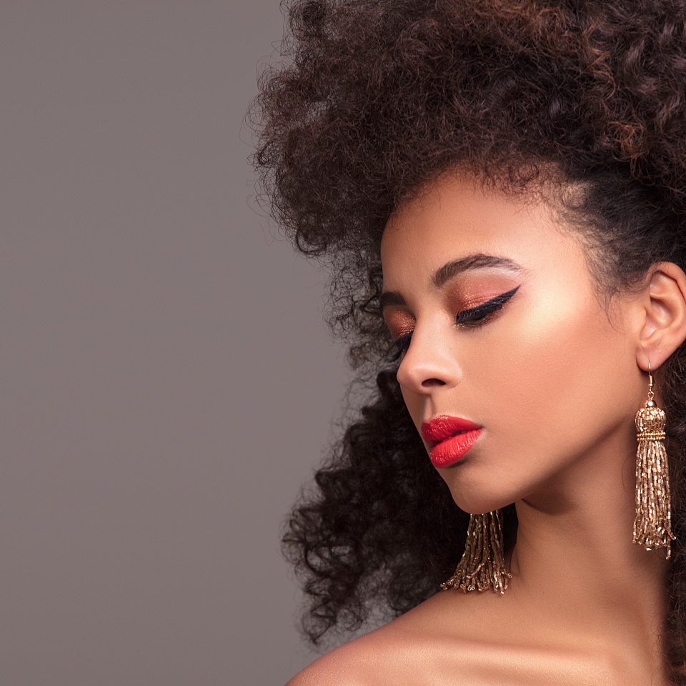 Beauty portrait of attractive african american woman with long afro hairstyle and glamour makeup, studio shot.