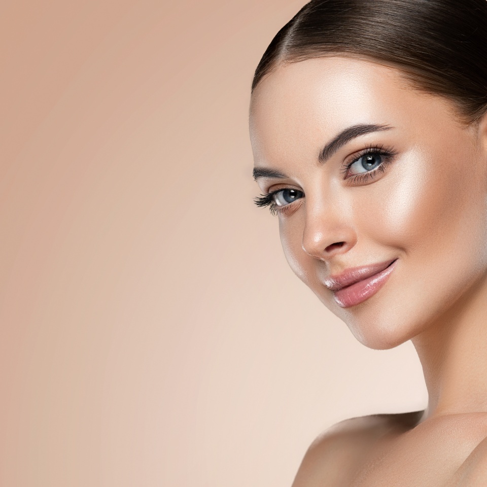 Beautiful young woman with clean fresh skin touching her face . Girl facial treatment . Cosmetology , beauty and spa . Female model, care concept