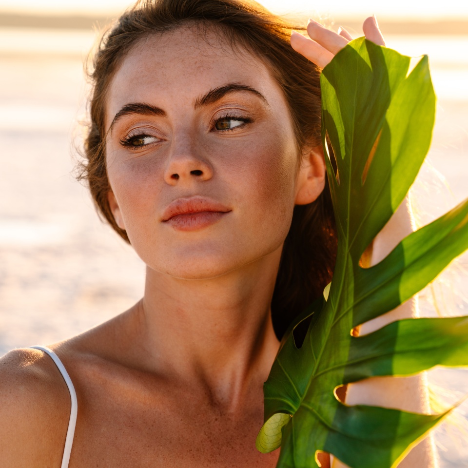 Portrait of the beautiful young girl close-up at the beach