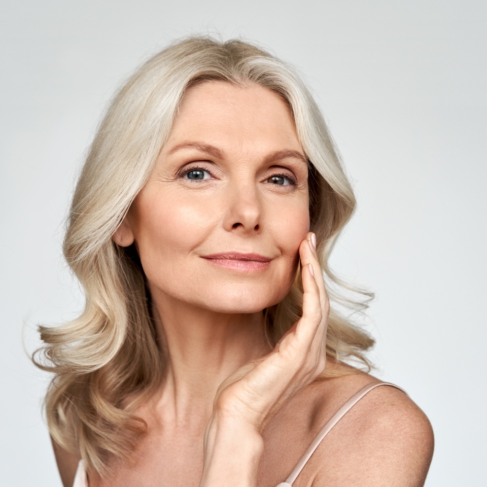 Beautiful gorgeous 50s mid aged mature woman looking at camera isolated on white. Mature old lady close up portrait. Healthy face skin care beauty, middle age skincare cosmetics, cosmetology concept