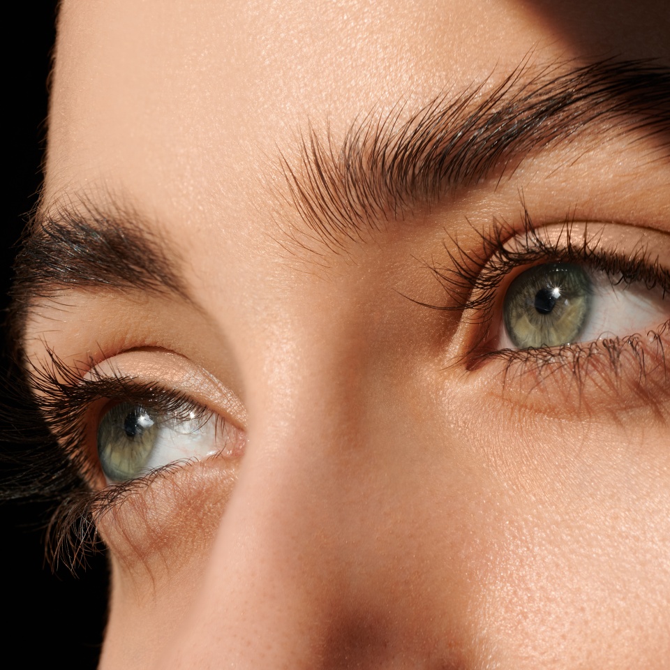 female green eyes with long eyelashes close up. look away