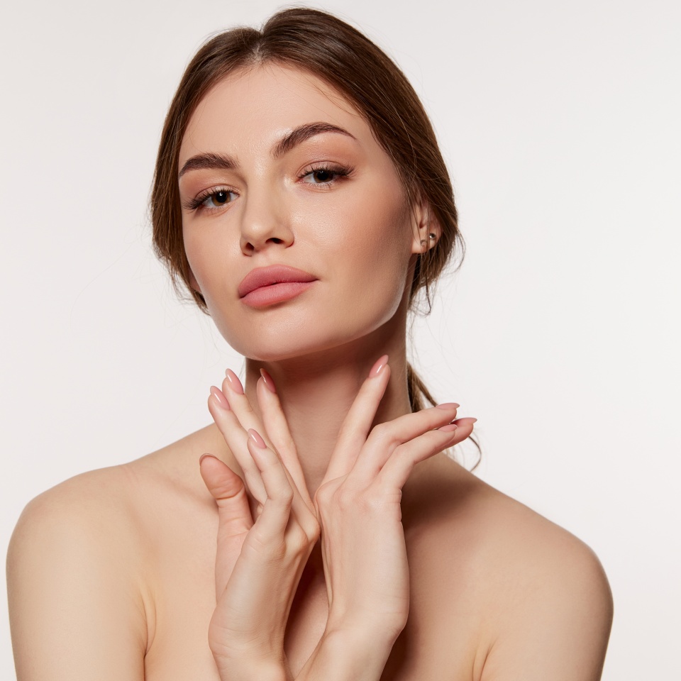 Portrait of young beautiful woman with perfect smooth skin isolated over white background. Facebuilding. Concept of natural beauty, plastic surgery, cosmetology, cosmetics, skin care