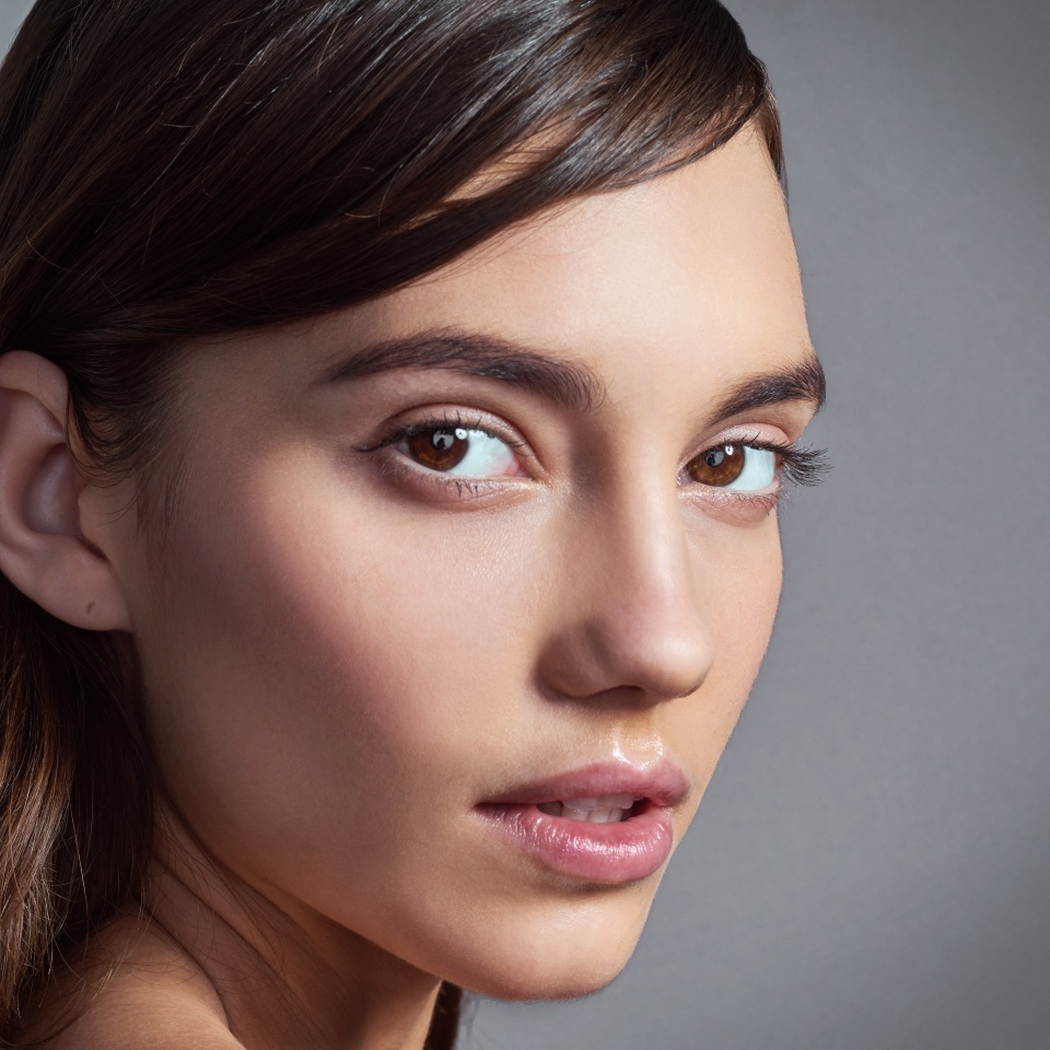 Portrait, natural and beauty of woman with glow, shine and health isolated on gray studio background. Face, skincare and confident model with cosmetics at spa for dermatology, makeup and wellness