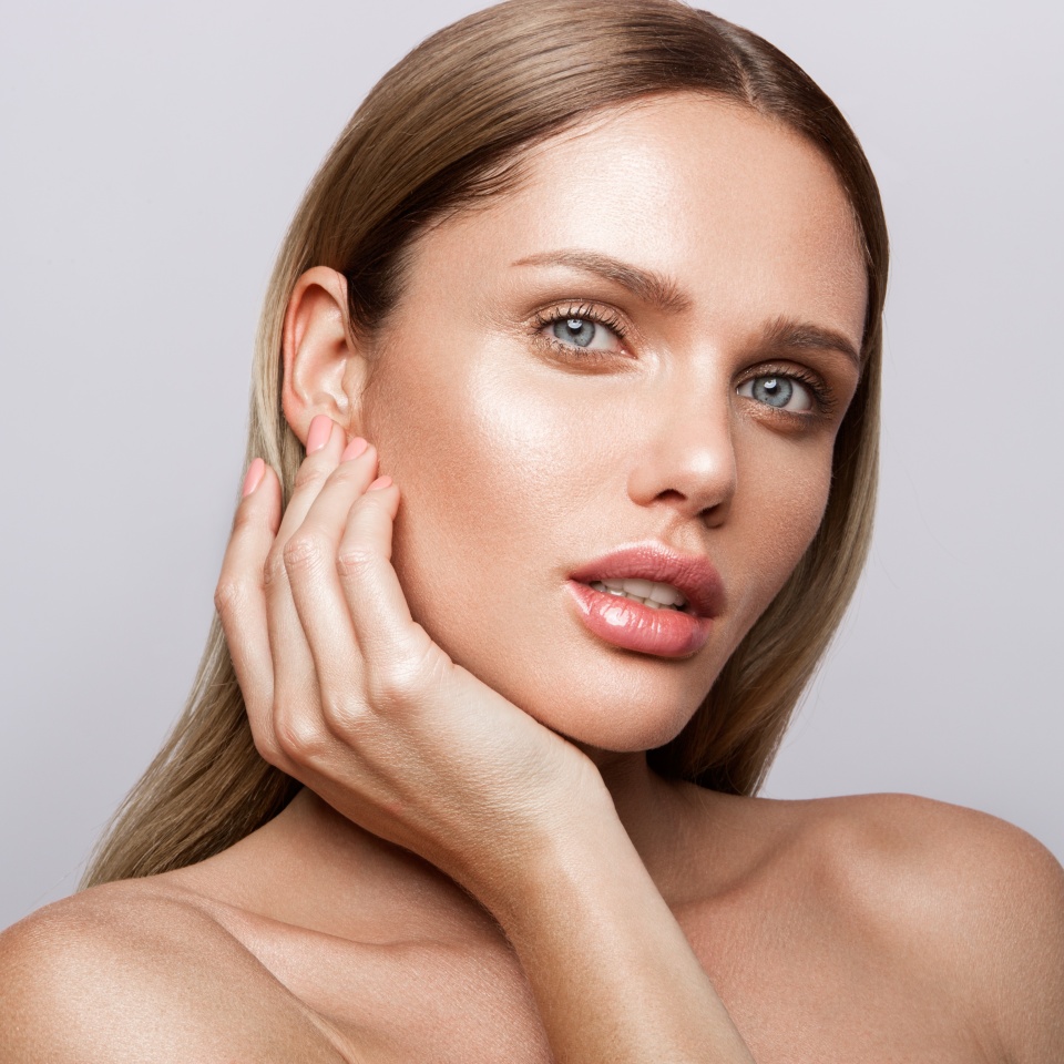 Beauty portrait of model with natural make-up. Fashion shiny highlighter on skin, sexy gloss lips make-up